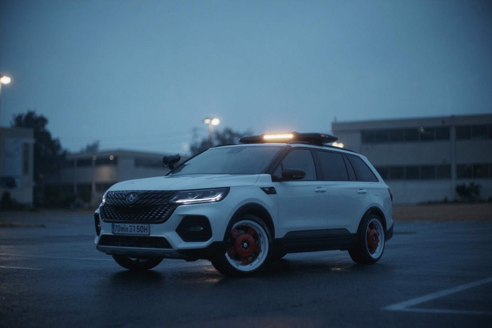 A marked security patrol SUV with a roof light bar at dusk in a commercial lot